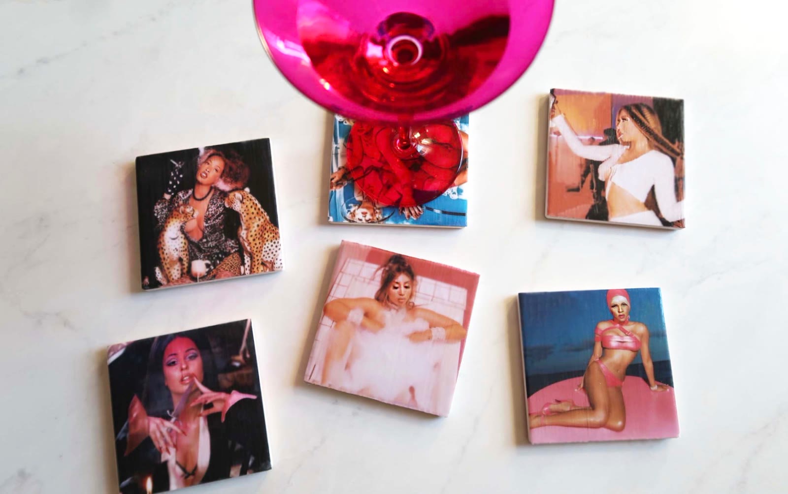 Six Icon Coasters arranged on marble with a pink martini glass